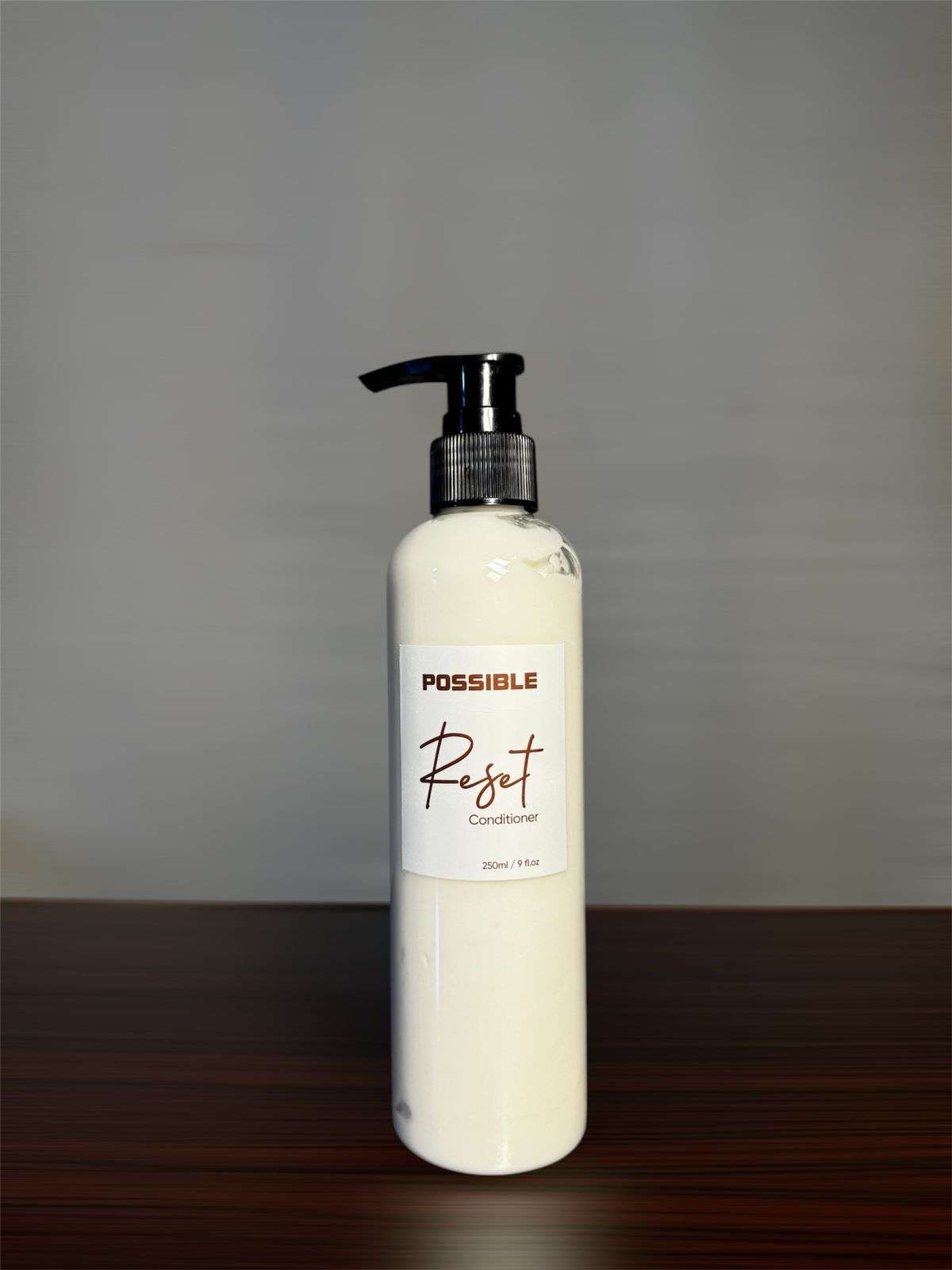 milky conditioner in a transparent 250 ml bottle named as Reset Conditioner with black screw pump